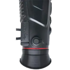 Close-up of a black camera lens showing the textured grip, focus/zoom ring, and a thin red accent around the base.