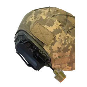 Close-up of a camouflage military helmet with a night-vision goggle mount and stitched fabric patches.