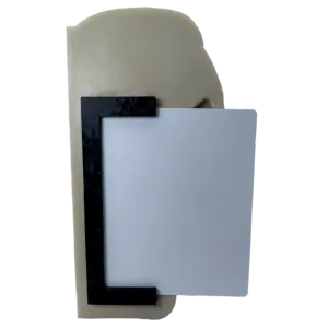 Close-up of a beige curved plastic piece with a black decorative rectangular frame and a light gray panel overlapping it.